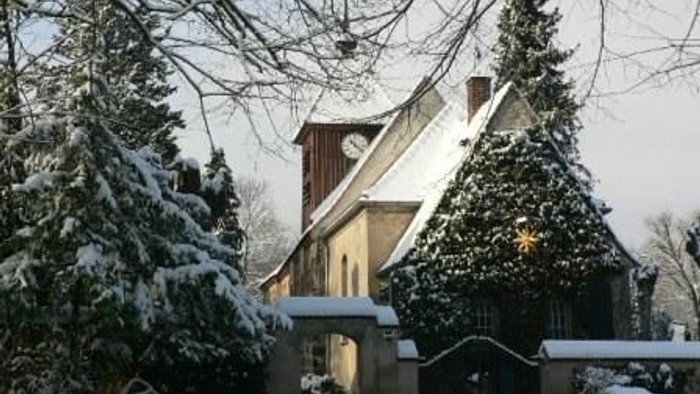 Schneebedeckte Bäume und ein Haus im Winter.