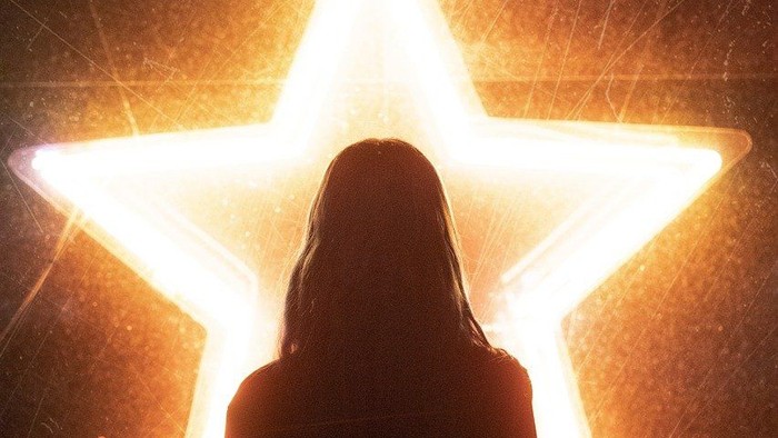 Person steht vor beleuchtetem Stern