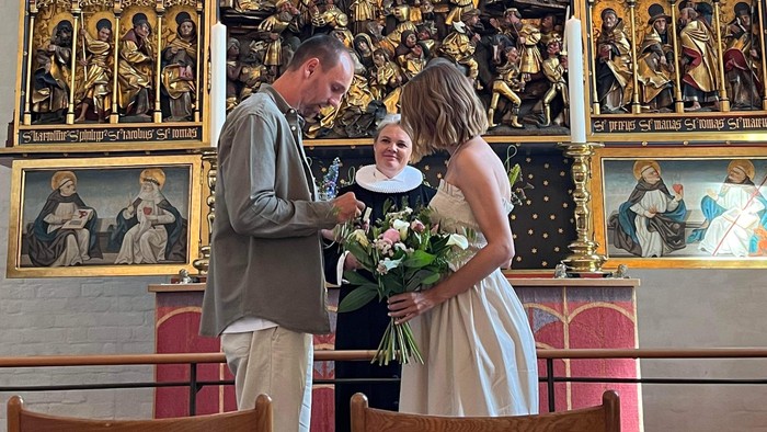 En bryllupspar i kirke foran altertavle