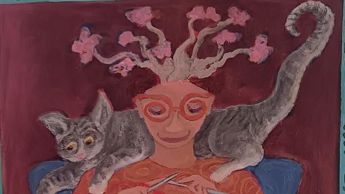 Billedet viser en kvinde med to katte og en håndværksbolle