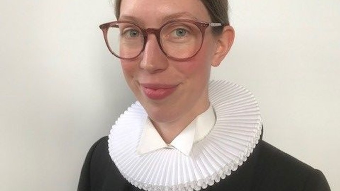 Kvinde med briller og hvid krage.