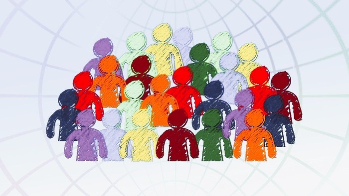 En gruppe af farvede figurer står sammen i en hal.