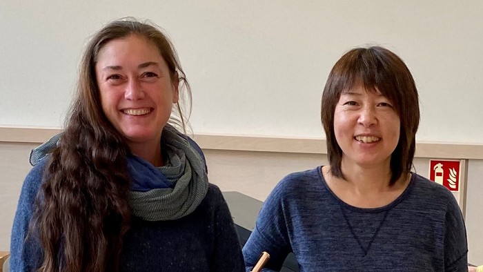 Drei Musiker posieren mit ihren Instrumenten in einem Übungsraum