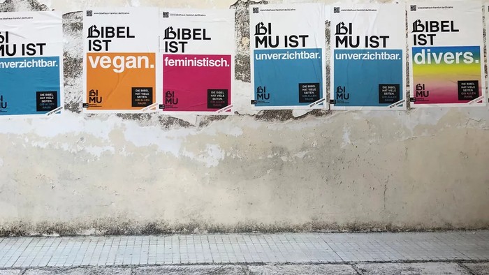 Bunte Plakate an einer verwitterten Wand