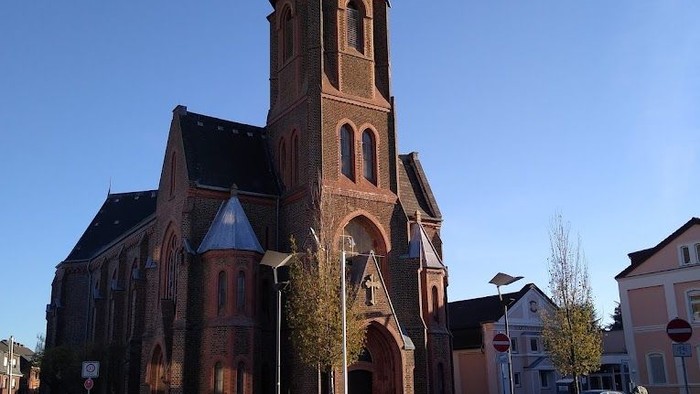 Große Kirche mit hohem Turm an der Straße.
