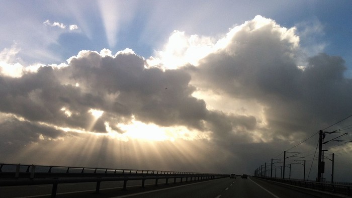 En vej med solskin bagved skyerne