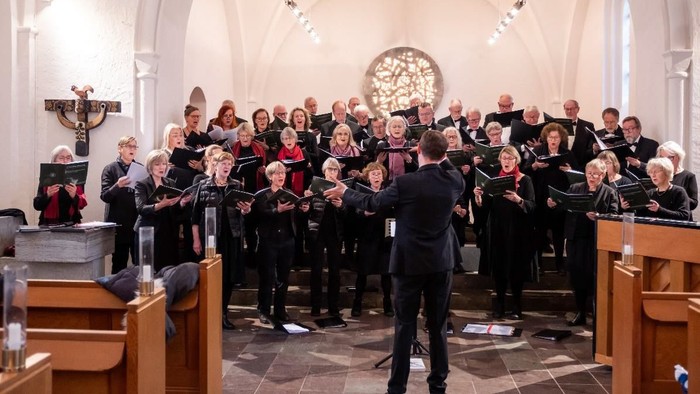 En kor sang i kirke med dirigent.