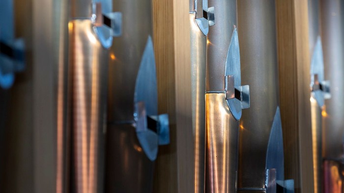 En række skarpe knive på en vegg