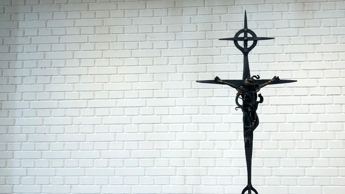 En svart krucifix på en hvid mur