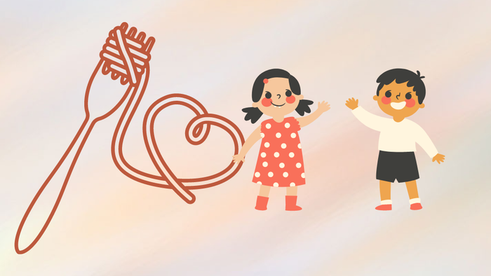 To børn holder hånd og står ved en kærlighedshjerte lavet af spaghetti.