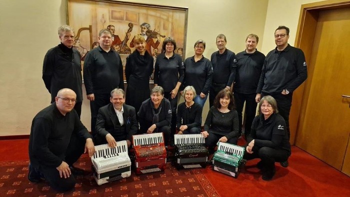 Ein Ensemble von Musikern posiert mit ihren Instrumenten