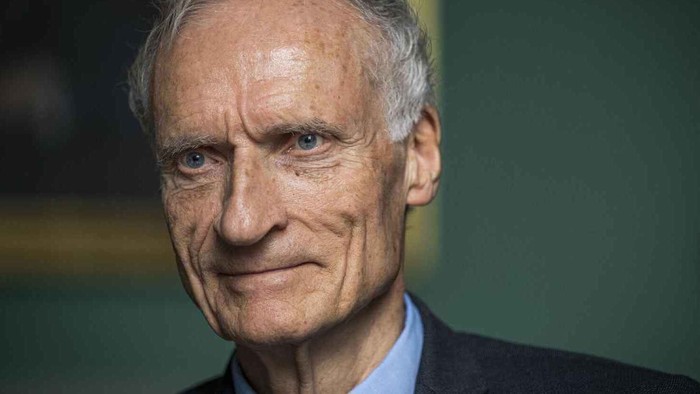 En eldre mand med grå hår og skæg, der ser direkte i kameraet.