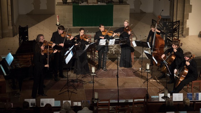 Ein Orchester spielt in einer Kirche Konzerte