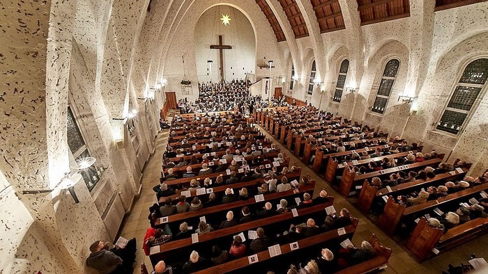 Große Kirche mit vielen Gläubigen in den Bänken, große Kreuzigungsszene im Altarraum.