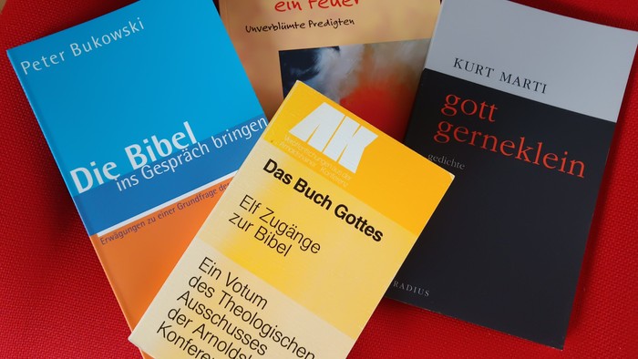 Vier Bücher über Philosophie und Religion auf rotem Hintergrund