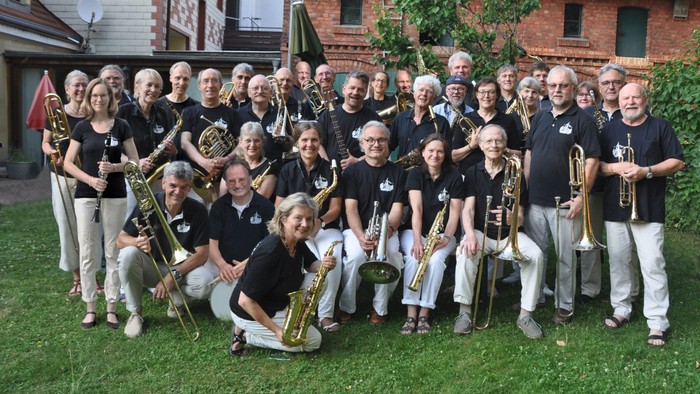 Eine Gruppe von Musikern posiert mit ihren Instrumenten im Freien