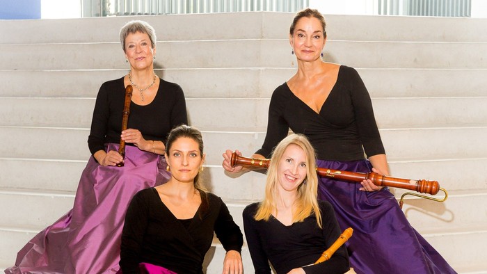 Fire kvinder sidder på trin med stokke i hånden