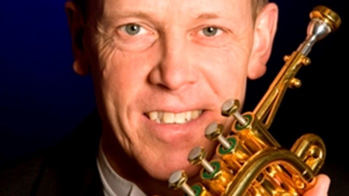 En mand spiller trompete.