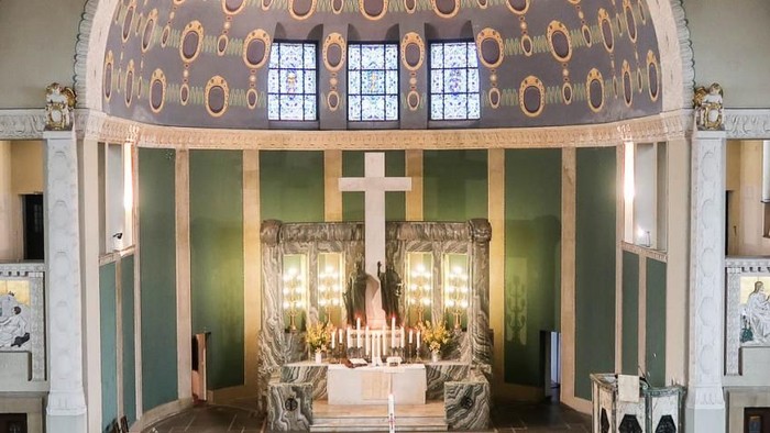 Großer, prunkvoller Raum mit hohen Säulen und verzierten Wänden, ausgestattet mit antiken Möbeln und Kronleuchtern