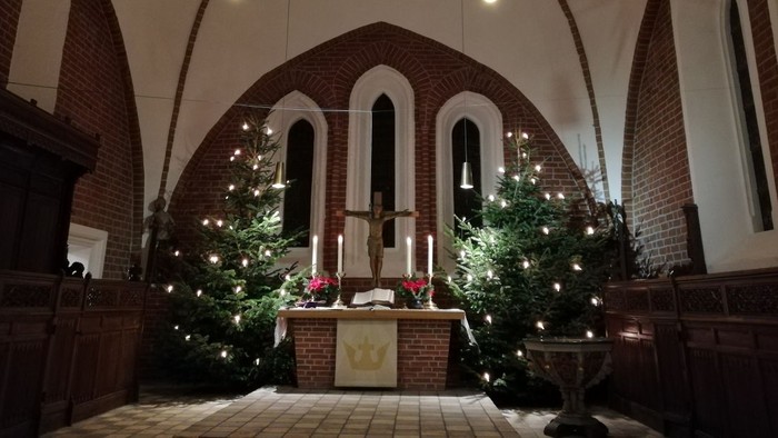 Innenraum einer Kirche mit Weihnachtsdekoration und Sternenleuchte
