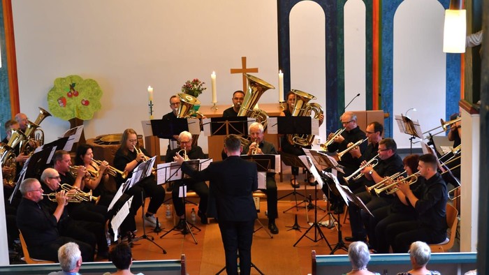 Ein Kirchenchor tritt mit verschiedenen Blechblasinstrumenten auf.