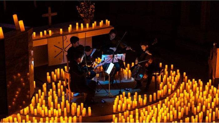Streichquartet Pianist im Altarraum der Apostel-Paulus-Kirche, umgeben von Lichtern am Boden