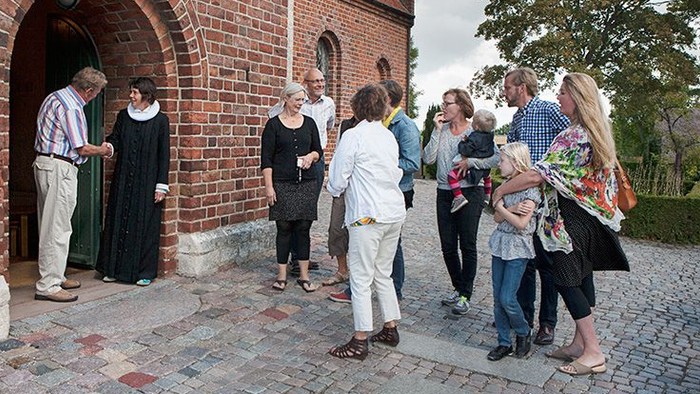 En gruppe af mennesker går ud af en murstensport.