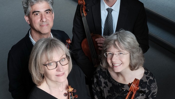 Fire musikerer med strengeinstrumenter.