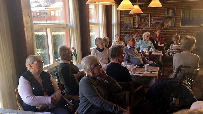 En gruppe mennesker sidder om bord i et restaurant.