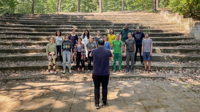 Eine Gruppe von Menschen posiert auf einer steinernen Treppe in einem Wald.