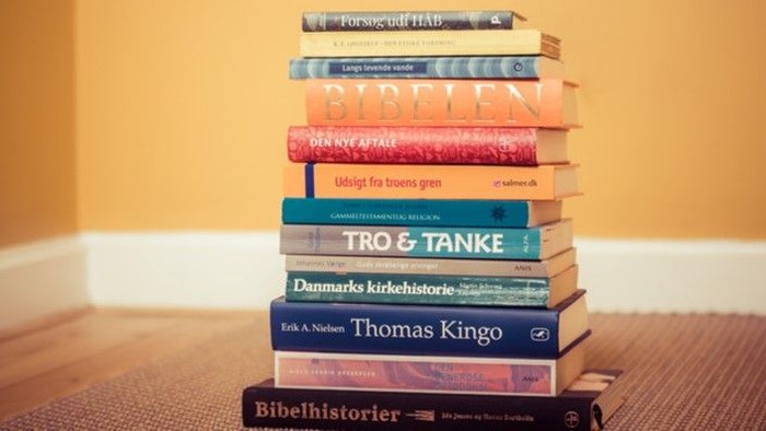 En stabel af bøger på gulv.