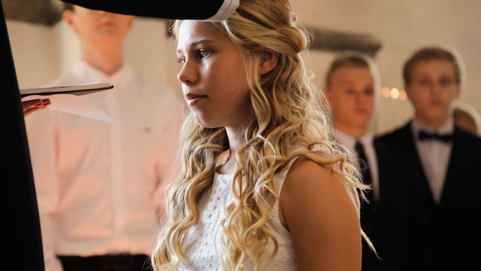 En ung pige med bløde bølger i håret ser sig selv i spejlet.