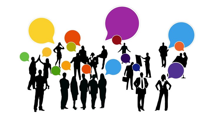 Verschiedene Menschen in Gruppen mit Sprechblasen, die Kommunikation symbolisieren