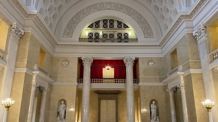 Indre del af stor, prægtig kirke med høje søjler og belysning.