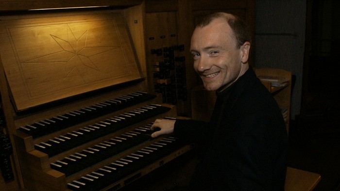 Mann spielt Orgel und lächelt