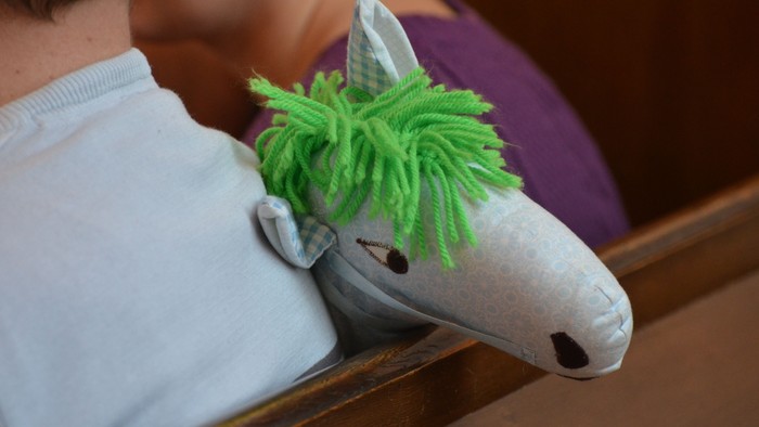 Et barn holder en grøn og hvid ponystøvle.