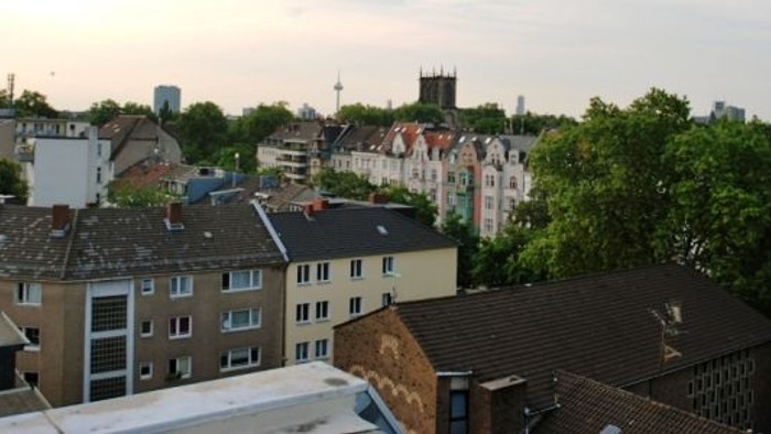 Stadtansicht mit Häusern und Bäumen bei Dämmerung