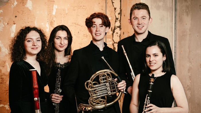 En gruppe af fem unge musikere poserer med deres instrumenter.