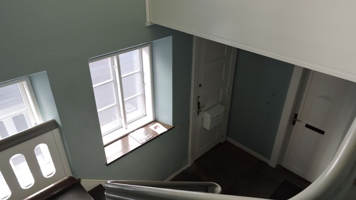 En række tømrer i et tomt værelse med et vindue og en dør.