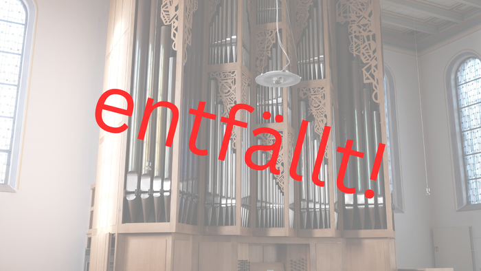 Ein Kircheninneres mit einem großen, verzierten Orgelpfeifenwerk und einem hellen, natürlichen Lichteinfall durch Fenster.