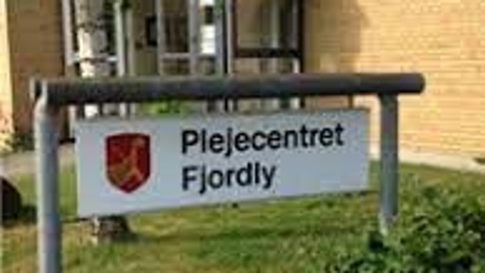 En skiltet med navnet "Plejecentret Fjordly" foran et hus.