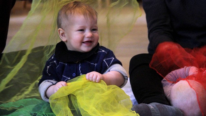 Børn spiller med papir og smiler