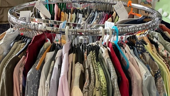 Ein Kleiderständer mit vielen bunten Kleidungsstücken in einem Raum