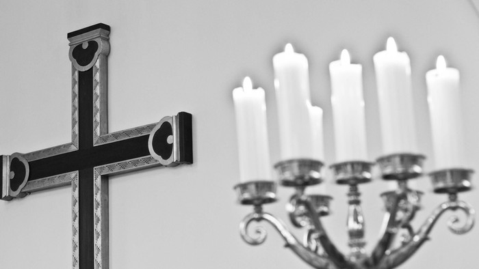 En svart kross og en kandleholder med lyse lygter