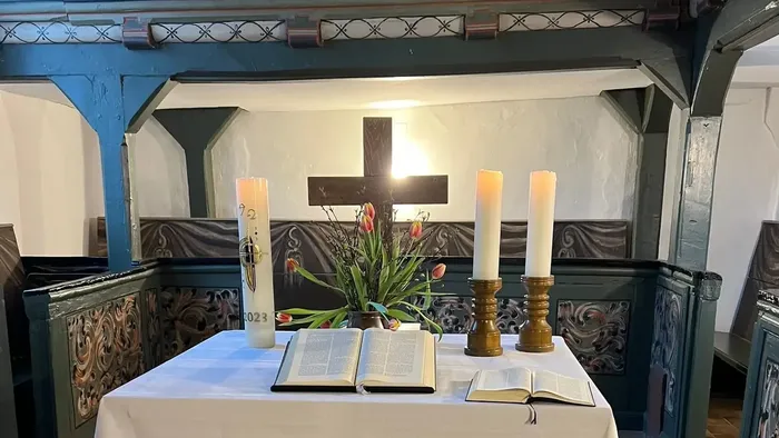 Altar mit Kreuz, Kerzen und religiösen Texten in einer Kirche
