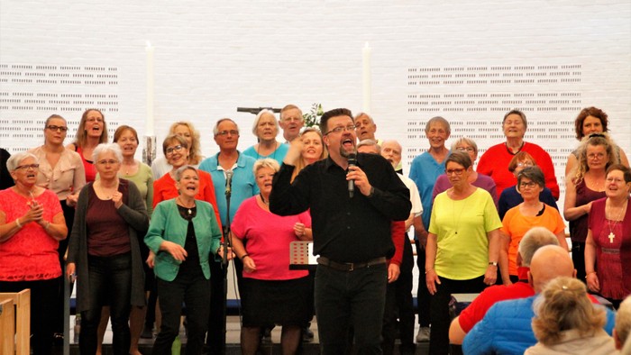 En gruppe af mennesker synger i kor.