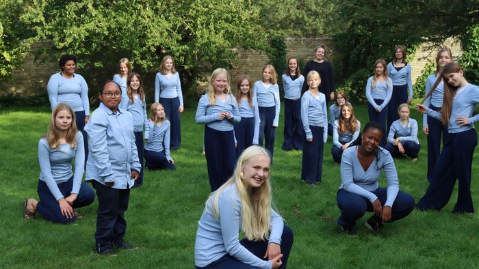 En gruppe af unge mænd og kvinder poserer i en park.