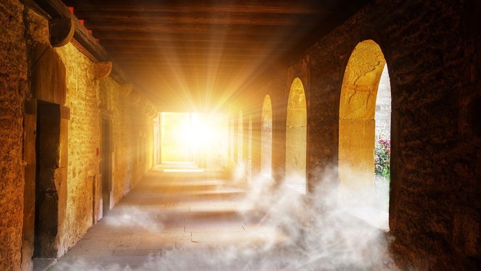 Ein langer, gewölbter Flur mit Licht am Ende und Nebel am Boden