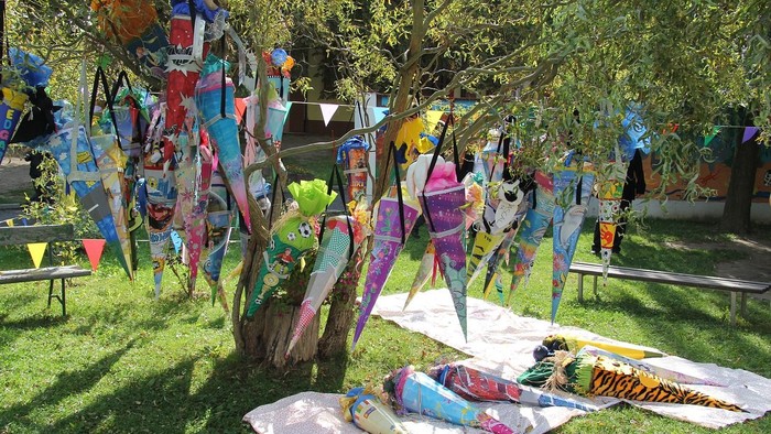 Bunte Drachen hängen an Bäumen im Park