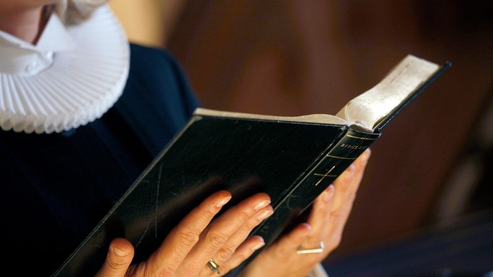 En person læser et håndskrevet bog.